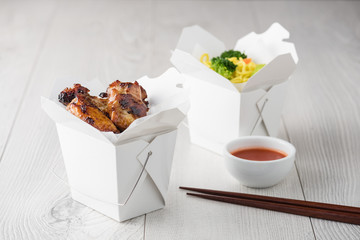 Chicken wings and noodles in take away noodles box