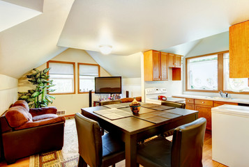 Dining and kitchen room interior with white vaulted ceiling.