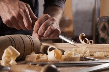 Hands of craftsman carve  with a gouge in the hands on the workbench in carpentry