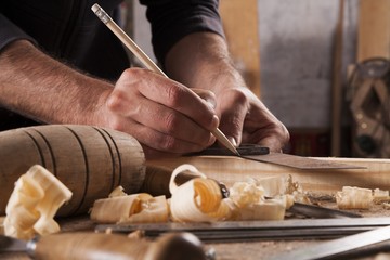 Obraz premium hand of a carpenter taking measurement of a wooden plank