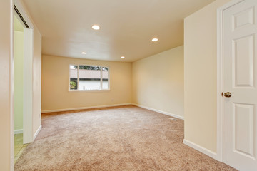Empty room interior in creamy colors with carpet floor.