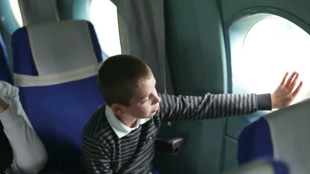 Mother and son are flying in an airplane