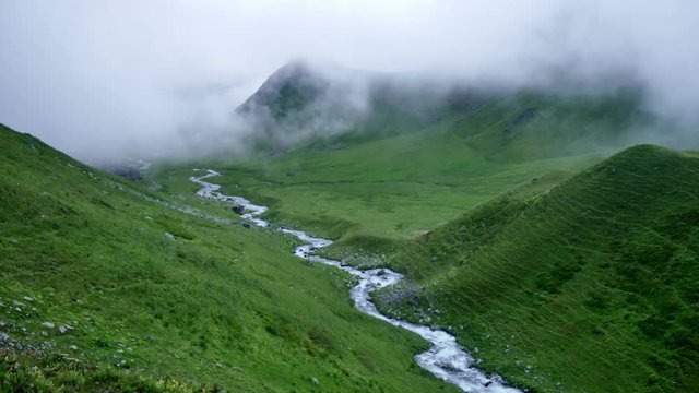 fog and clouds rolling over mountain green valley and winding River in Kavkaz region