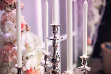 A silver candelabra with a bouquet of pink flowers