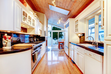 White kitchen cabinets with black counter tops in luxury house.