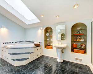 Master bathroom with blue marble tile floor and corner bath tub.