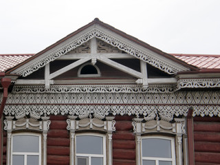 The windows with beautiful architraves in old wooden house. Ulan