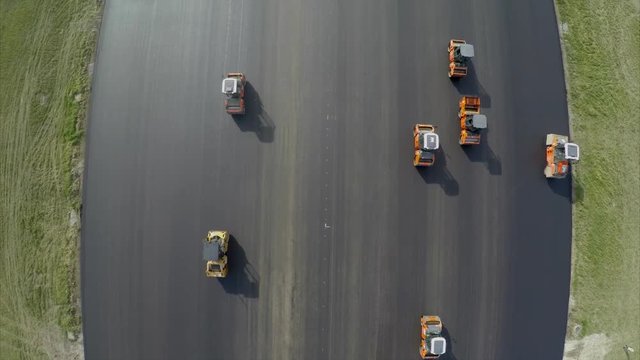 Aerial view of asphalt rollers at airport taxiway rehabilitation
