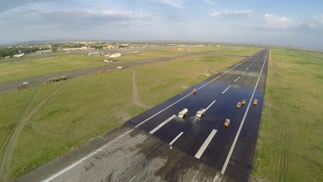 Aerial view of asphalt rollers at airport taxiway rehabilitation