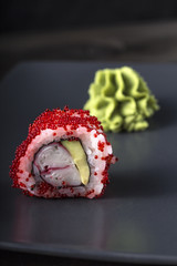 Sushi. Tobico Roll served on grey plate with wasabi.