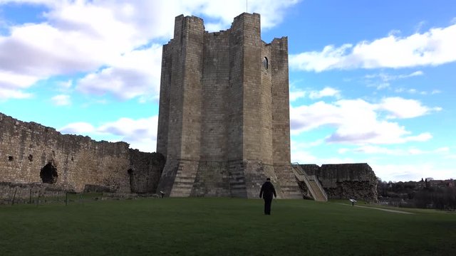 Conisbrough Castle England woman in courtyard. Medieval fortification built in the 11th century. Maintained by English Heritage as a historical landmark,  Ancient Monument and education.
