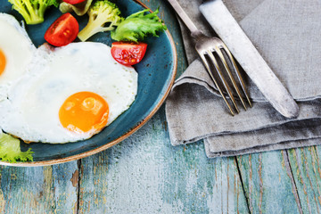 Two fried eggs and vegetables