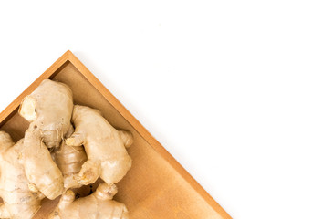 Closeup top view ginger on wooden tray with white background