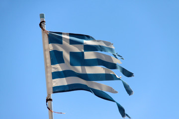 Flagge von Griechenland vor blauem Himmel zerfetzt