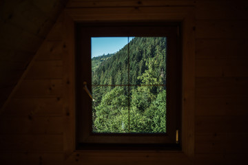 Beautiful view from rustic wooden house. Nature landscape seen through window.