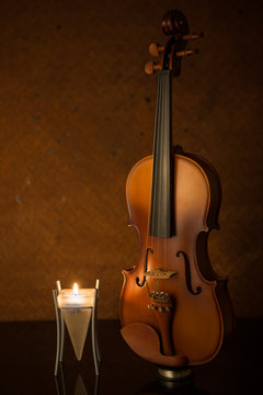 classical violins with  candle on old steel background