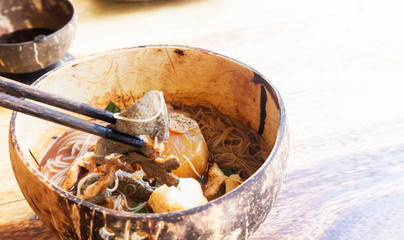 Rice noodle soup with Cooked Liver in wood bowl on wood background table, selective focus
