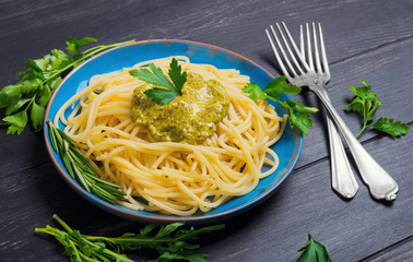 Pasta spaghetti with pesto sauce on blue ceramic plate
