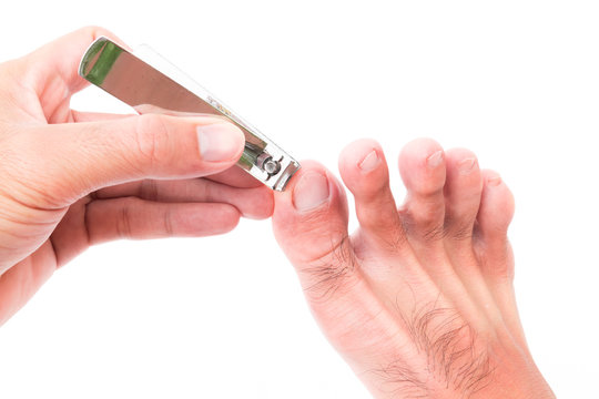 Man Hand Cut Toenails On White Background, Health Care Concept