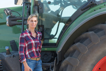 Female farmer and her tractor - 117598325
