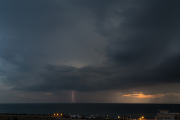 Fototapeta na wymiar Lightning storm over the cemetery and sea of Nahariya during sunset