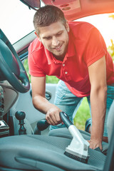 Man Hoovering Seat Of Car During Car Cleaning