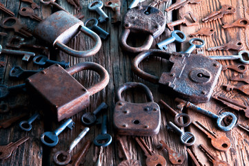 Old rusty padlock and keys on wooden background