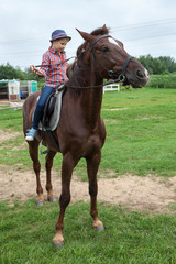 Obraz premium Little country girl trying to control the horse using a bridle
