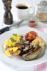 English breakfast with egg, sausage, vegetable, mushrooms, bread and tomato.