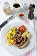 English breakfast with egg, sausage, vegetable, mushrooms, bread and tomato.