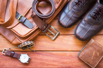 Men's casual outfits with leather accessories on wooden background