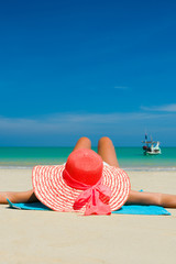 Fit woman in sun hat and bikini at beach