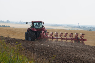 Tractor with plow agriculture on arable land processes