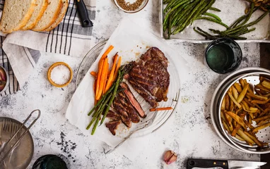 Foto auf Acrylglas Overhead of Dinner food tabletop with Bbq fillet steak and grilled veggies. © casanisa