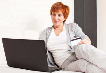 Mature woman with credit card and laptop