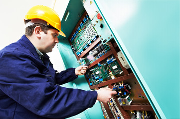 adult electrician builder engineer worker testing electronics in switch board