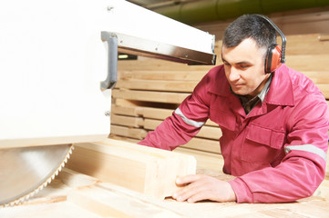 carpentry worker cutting wood cross beam