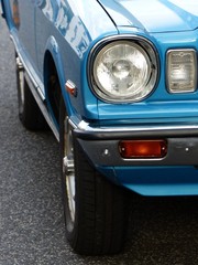 Scheinwerfer und Blinker einer blauen japanischen Limousine der Achtziger Jahre im Sommer beim...