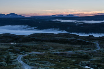Sunrise in the Swedish mountains, very early during summertime. Morning mist down in the valley.