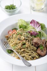 Italian pasta spaghetti with pesto sauce and meatballs