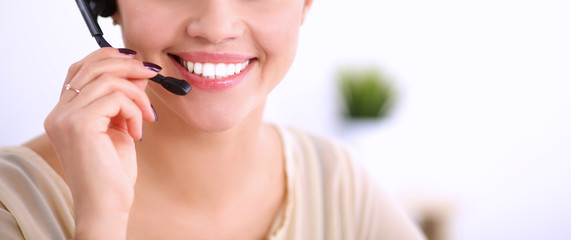 Portrait of beautiful business woman working at her desk with headset and laptop