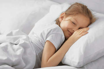 Cute sleeping girl in white bed