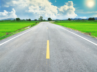 Fototapeta premium asphalt road between the cornfield and beautiful sky.