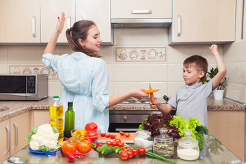 Mom with child having fun in the kitchen during the preparation