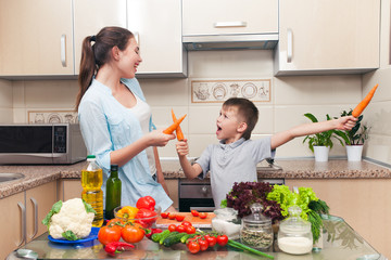 Mom with child having fun in the kitchen during the preparation