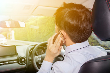 Asian businessman talking on phone while driving