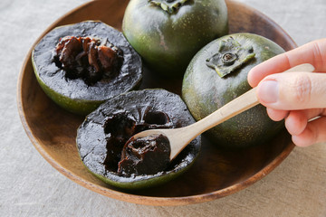 Black sapote chocolate pudding fruit in wooden plate