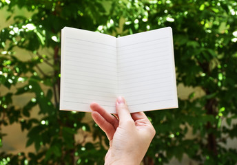 A white note book with lots of room for your text or image and a regular pencil on a wooden desk