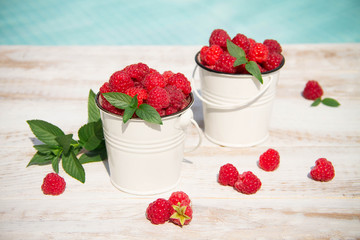 Sweet raspberries in bowl on wooden table. Close up, top view