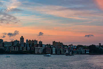Cityscape with dramatic colorful evening sky on the background. Modern waterfront buildings of Kirribilli suburb of North Sydney, Australia. Urban sunset landscape with space for text